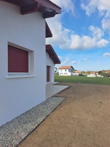 Bordures en acier et allée en gravier devant une maison basque, création de jardin