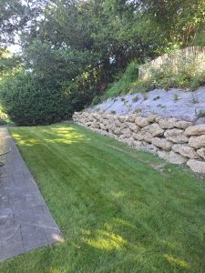 Enrochement en pierre et pelouse en pente réalisés lors d’un terrassement de jardin