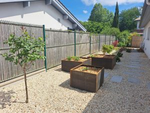 Jardinières en acier corten et pas japonais dans un jardin créé au Pays basque